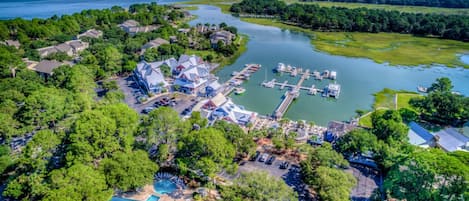 An aerial view of a lakeside property with a marina, a swimming pool, and residential buildings.