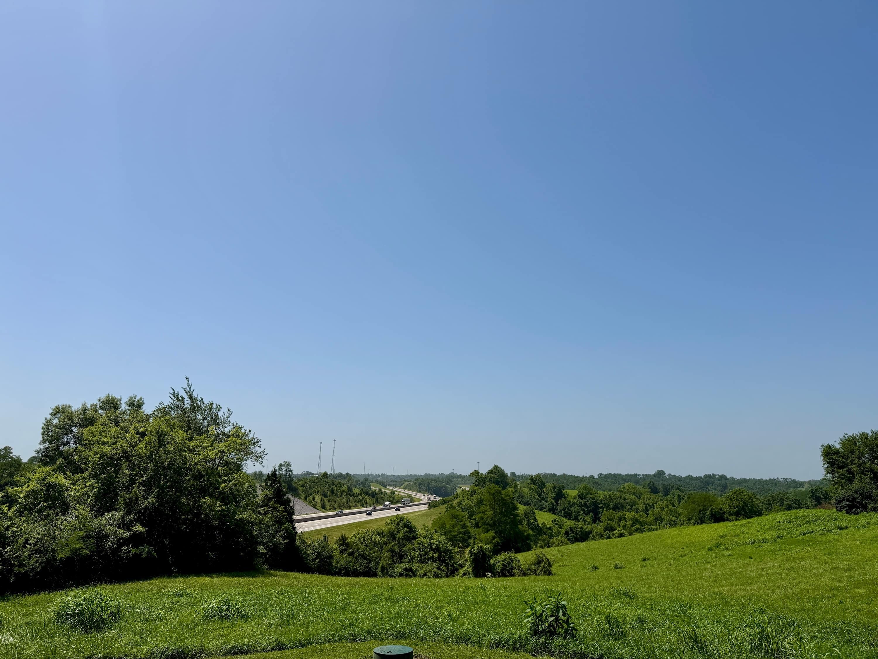 Eine grüne Landschaft mit einer Autobahn und Bäumen.