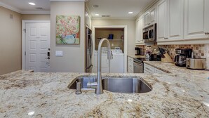 A kitchen with granite countertops, a stainless steel sink, a microwave, and a dishwasher. - 122 Abbington is a beautiful 3-bedroom, 3 bath villa in Palmetto Dunes (Hilton Head Island)