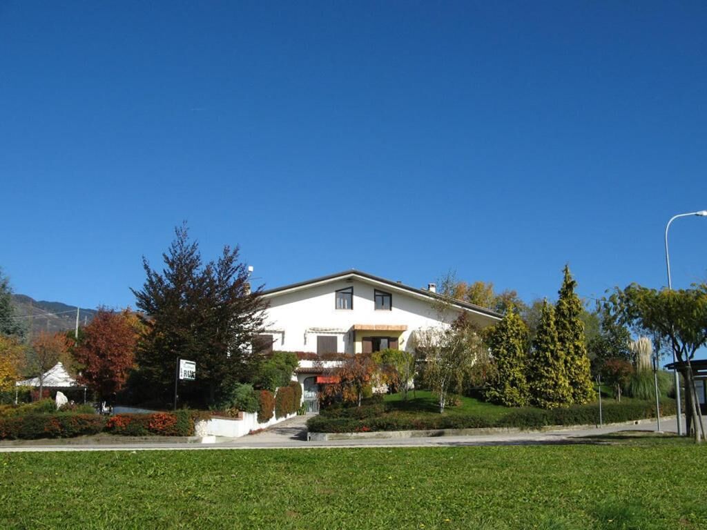 A two-story house with a front lawn, a driveway, and a street lamp.