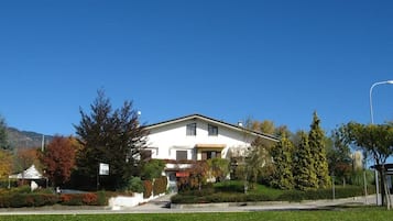 A two-story house with a front lawn, a driveway, and a street lamp.
