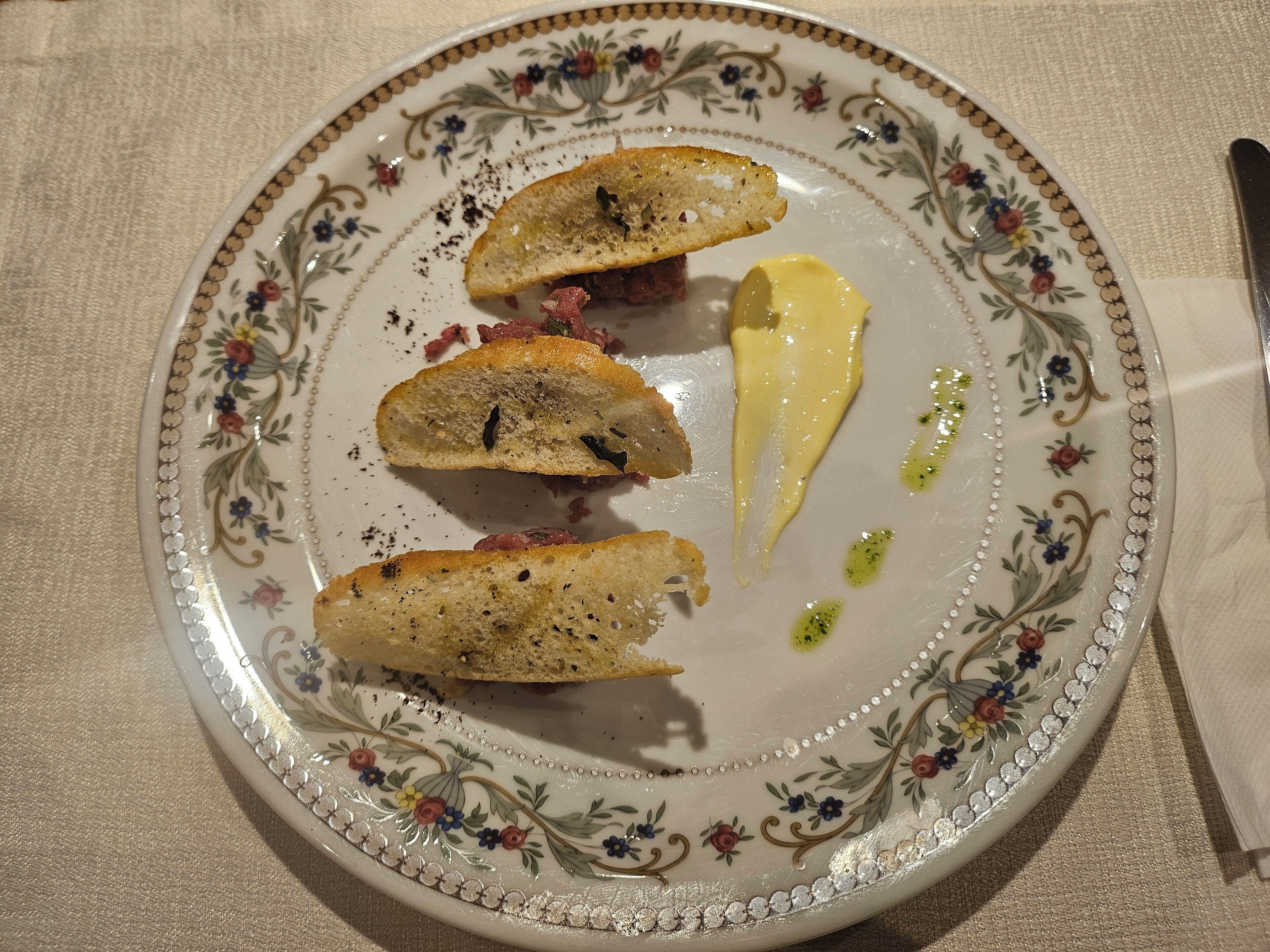 A plate with three pieces of bread and a dollop of yellow sauce.