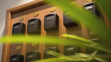 Une rangée de clés de chambres d’hôtel est disposée sur un panneau en bois, et les numéros de 201 à 210 sont visibles.