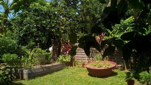 Ein gepflegter Garten mit vielfältigen Pflanzen und einem erhöhten Blumenbeet.