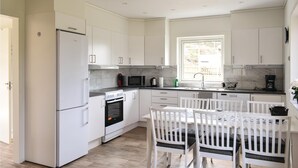 A modern kitchen with white cabinets, a built-in oven, a microwave, and a coffee maker.