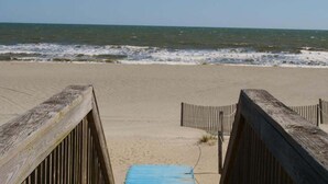 A beach with a wooden walkway leading to the water. - Las Palmas: Spacious 4BR, 2BA home in Holden Beach, ideal for family getaways. (Holden Beach)