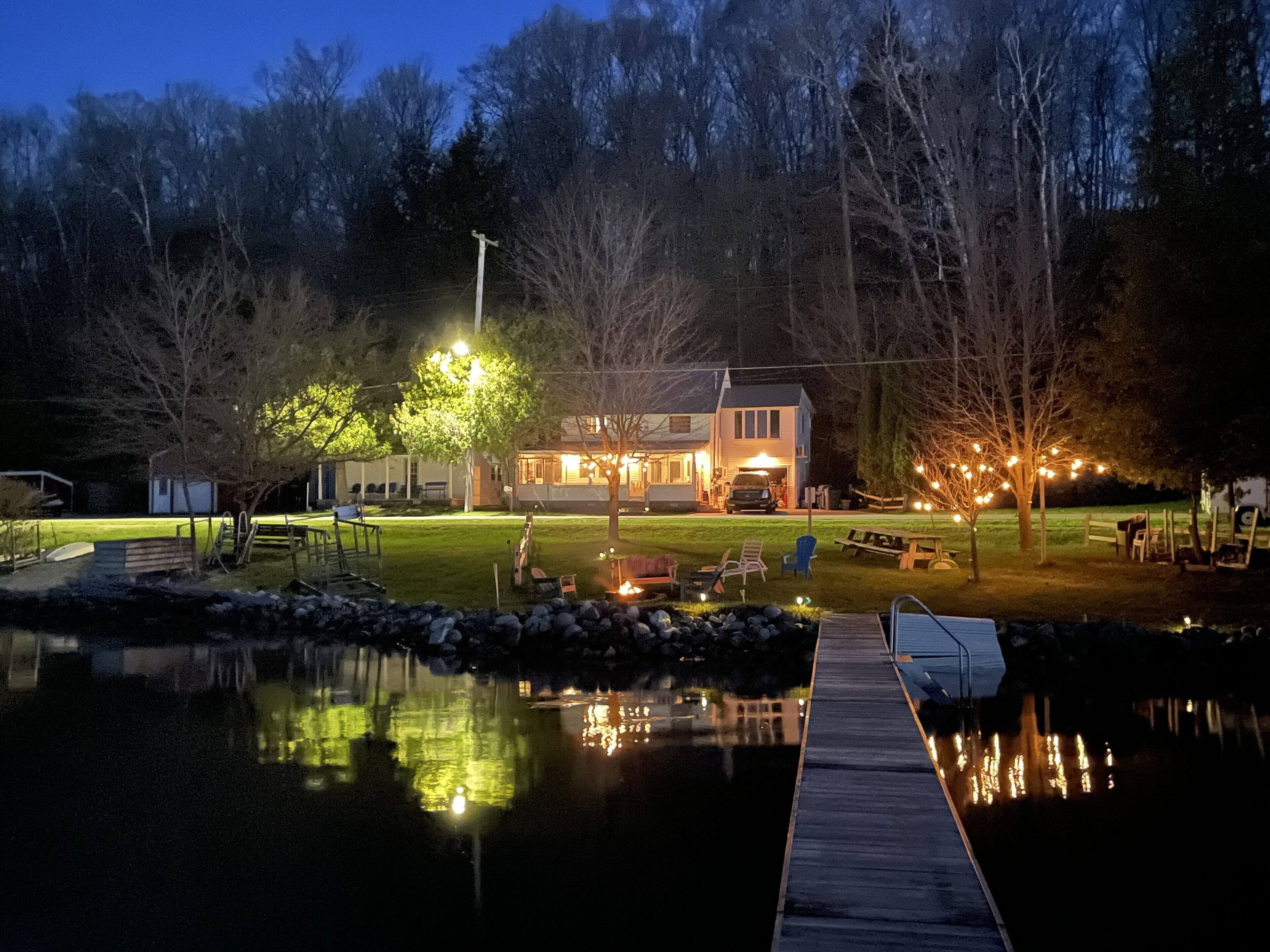 A lakeside property with a dock, a house, and outdoor seating.