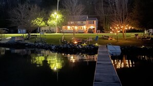 A lakeside property with a dock, a house, and outdoor seating.