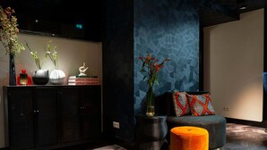 A modern living room with a sofa, ottoman, and decorative vases.