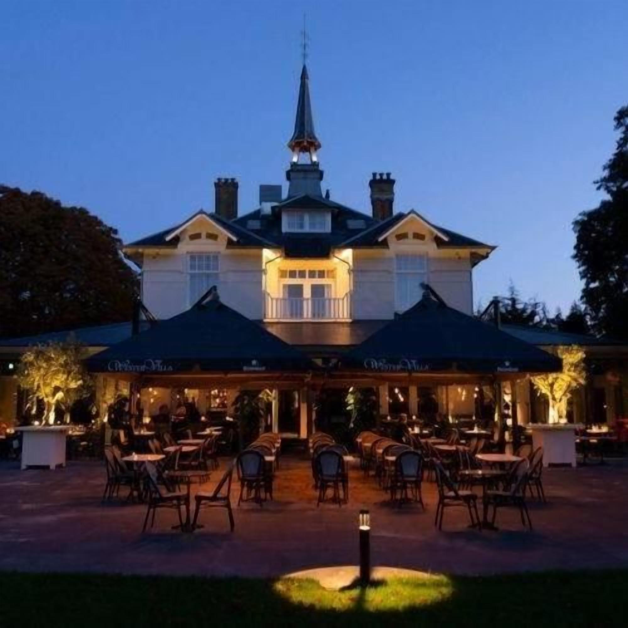 A building with a dining area, outdoor seating, and a covered section.