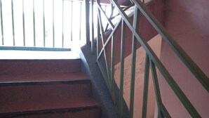 Una escala amb baranes de metall i un paviment de rajoles vermelles.