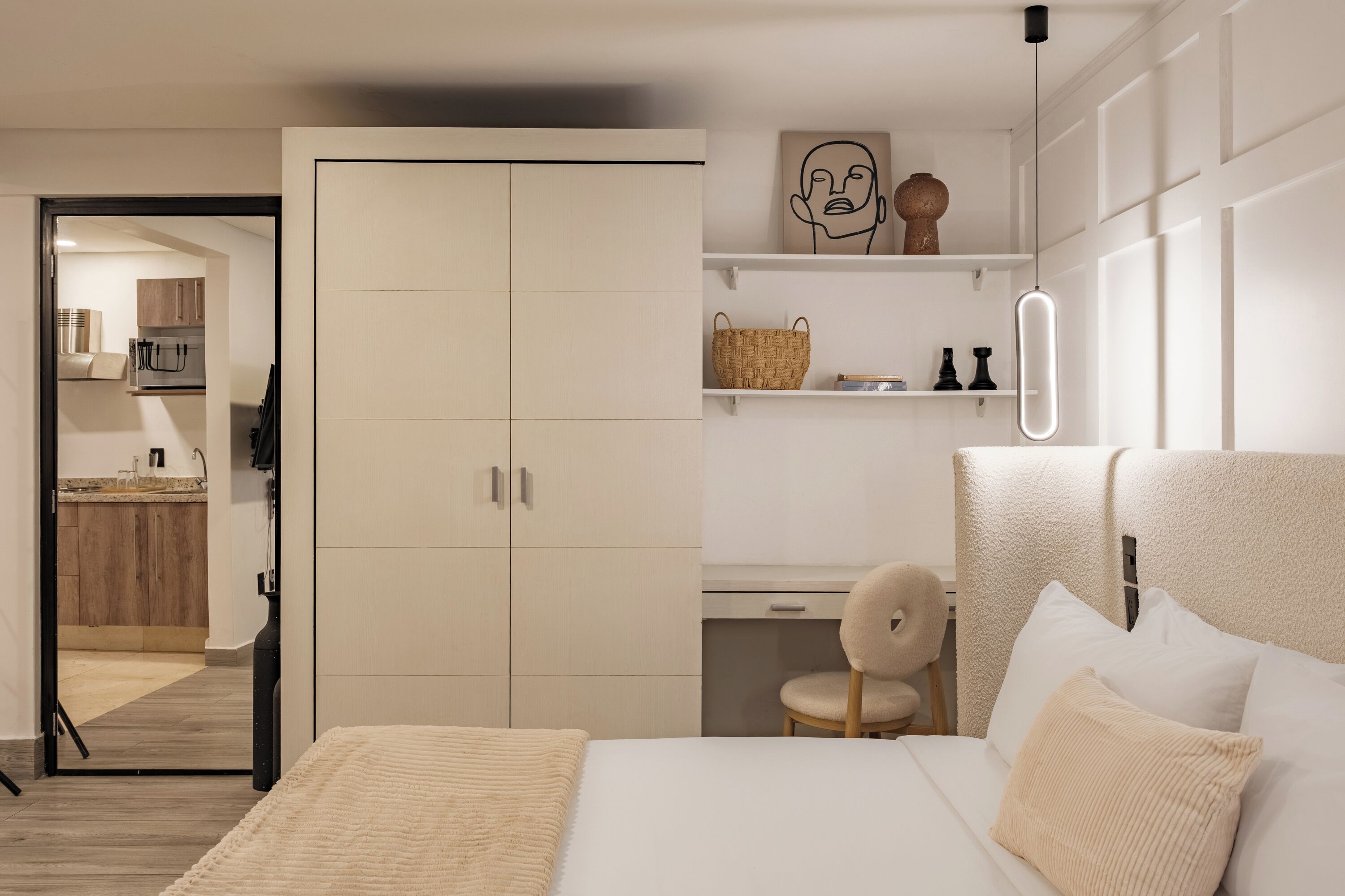 A modern bedroom with a bed, a wardrobe, and a desk area.