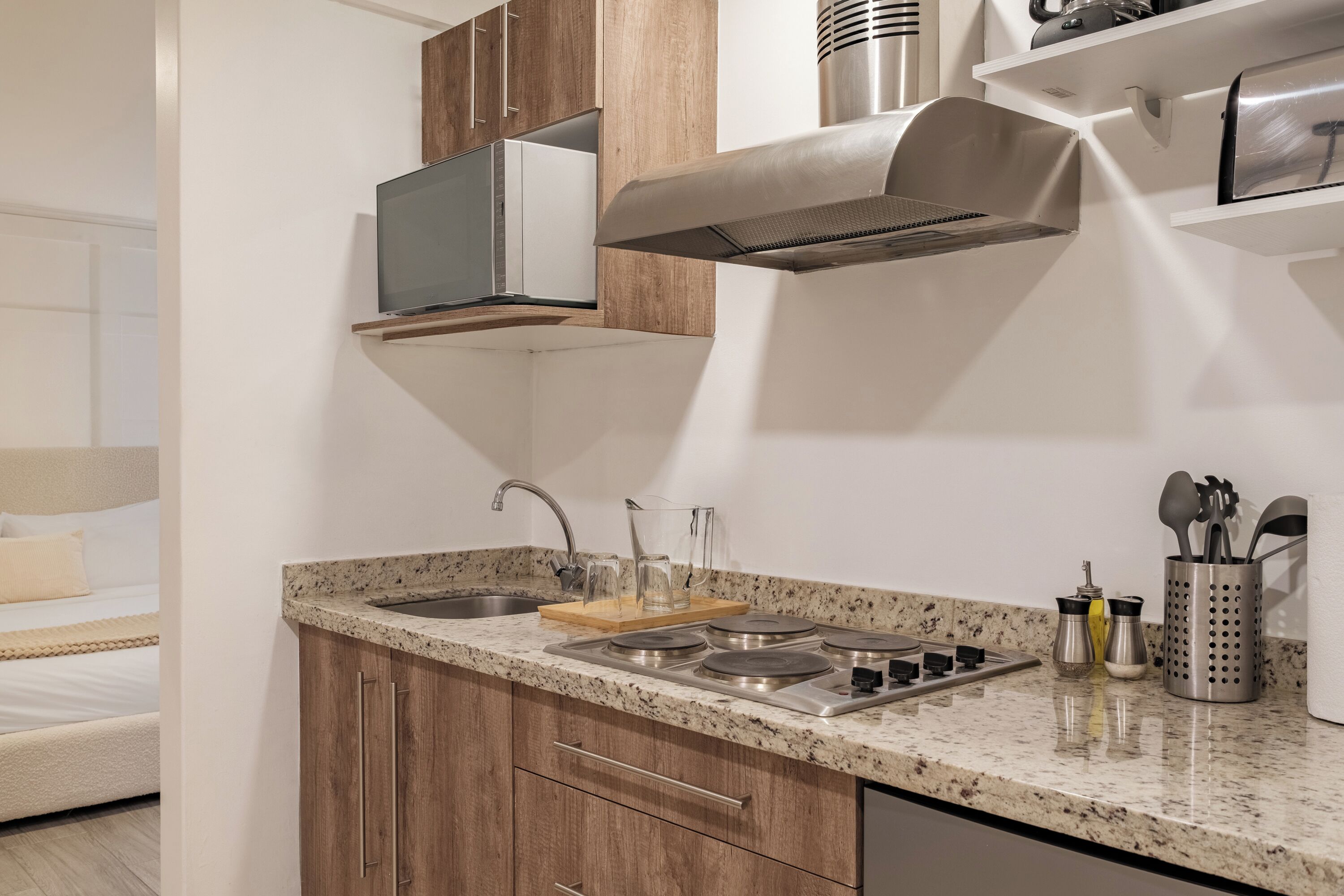 Uma cozinha moderna com bancada de granito, eletrodomésticos de aço inoxidável, armários de madeira e forno embutido.
