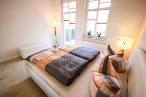 Cozy retreat with a neatly made bed, bedside table, and potted plant.