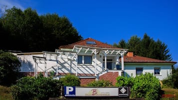 Experience the charm of traditional European architecture in this two-story hotel, surrounded by lush greenery and trees.