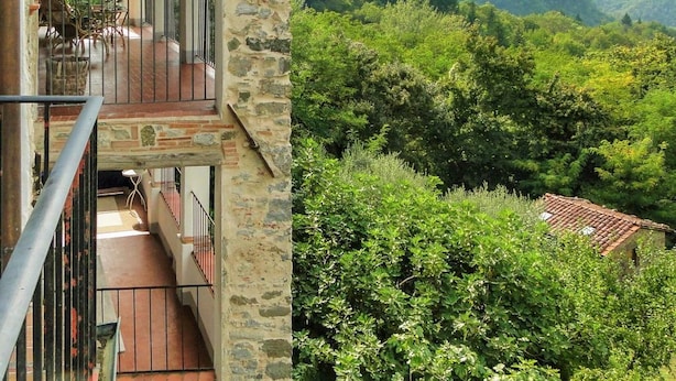 A stone building with a balcony overlooking a lush green valley and mountains. - Villa degli Archi, Private pool, mountain views, WIFI, 3 terraces, mature garden (Borgo a Mozzano)