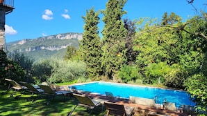 A pool area with lounge chairs and a view of mountains. - Villa degli Archi, Private pool, mountain views, WIFI, 3 terraces, mature garden (Borgo a Mozzano)