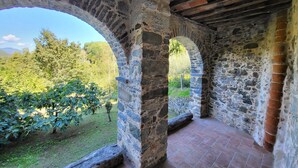 A stone corridor with arches leading to a garden. - Villa degli Archi, Private pool, mountain views, WIFI, 3 terraces, mature garden (Borgo a Mozzano)