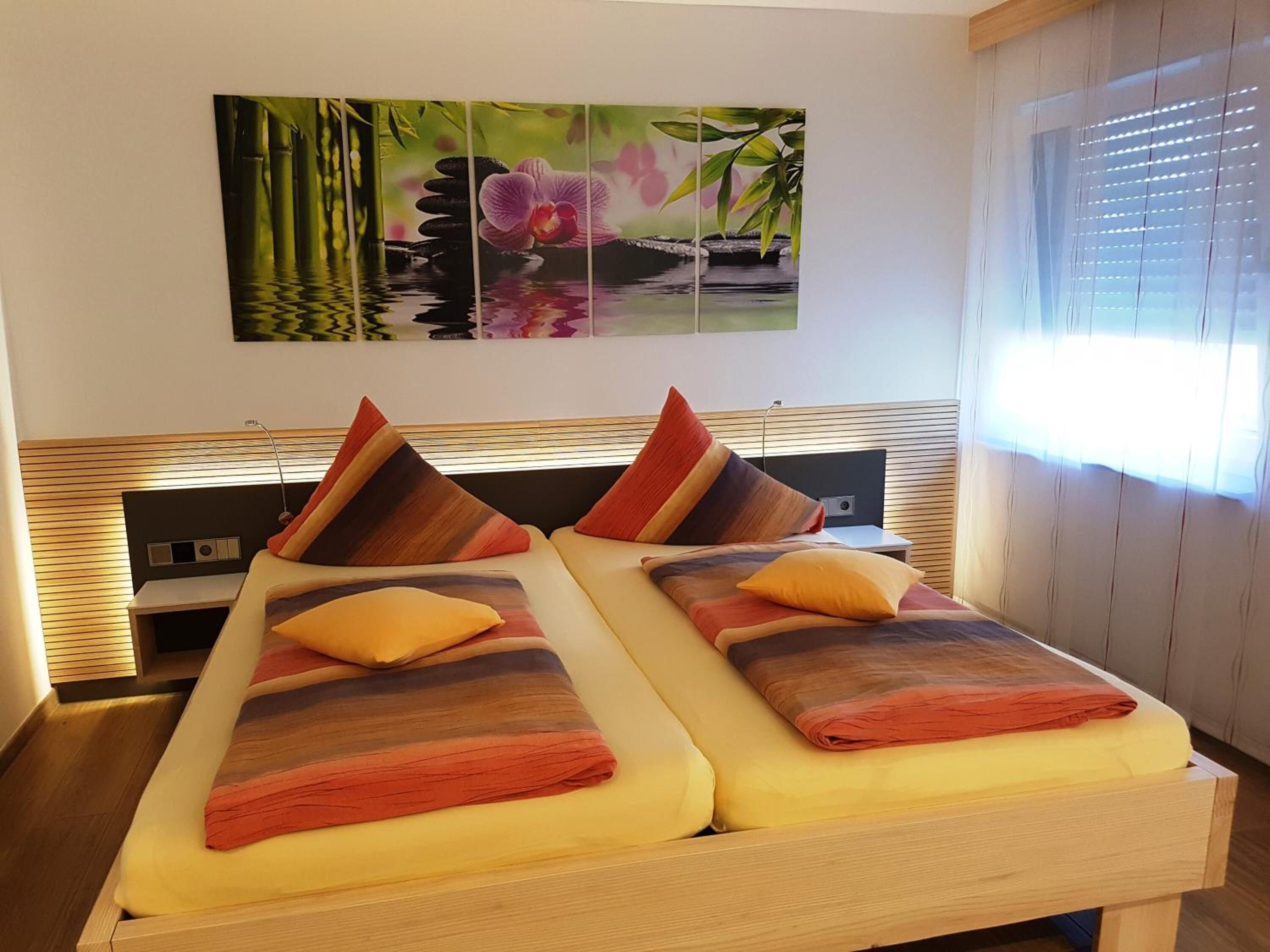 A double bed with a wooden headboard, two pillows, and a blanket.