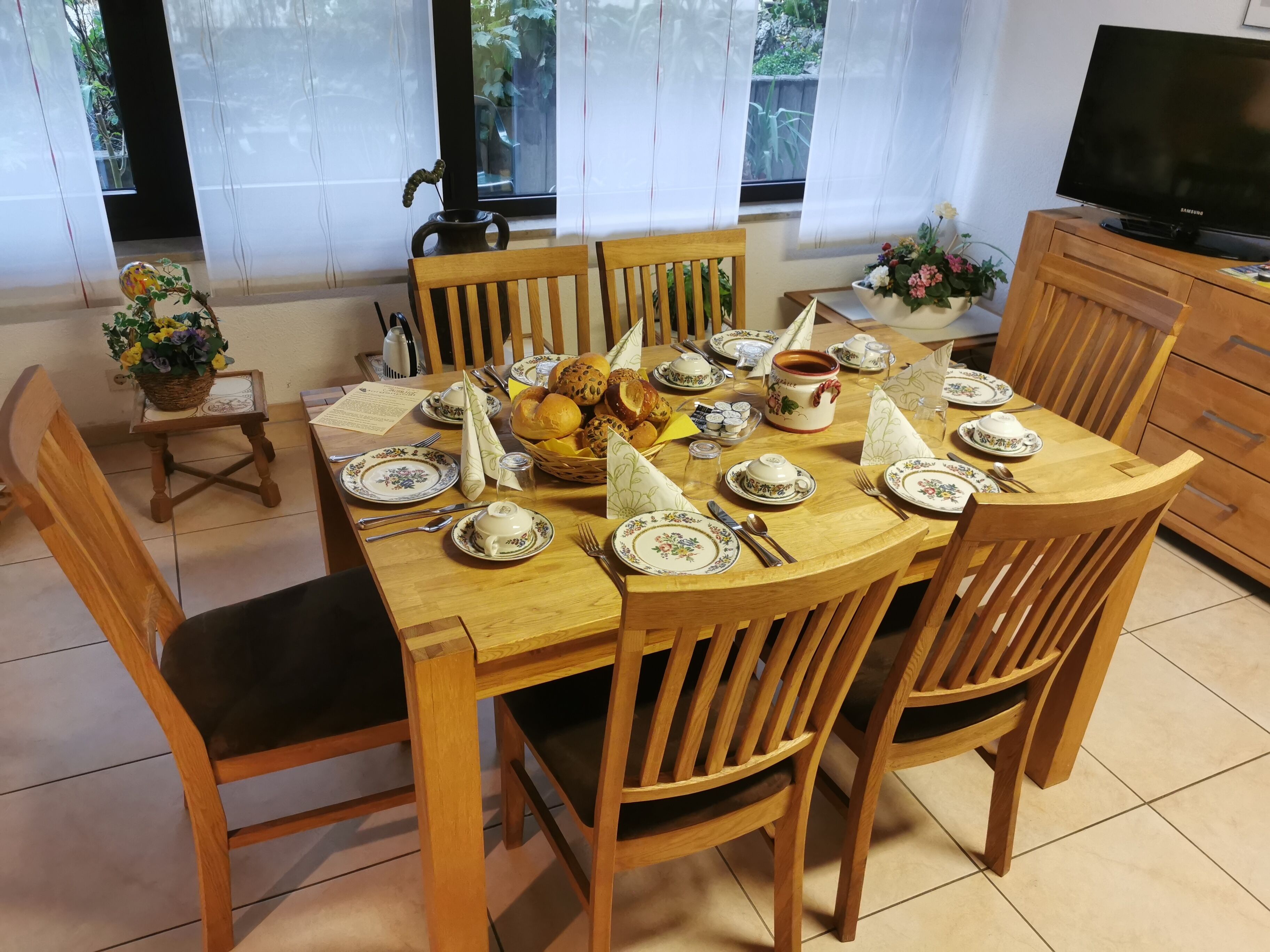 A dining table set with plates, cutlery, and a variety of food items.
