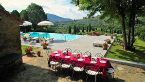 An outdoor dining area with a pool and mountain views. - Spacious Tuscan Villa with Large Pool near Castiglion Fiorentino. (Castiglion Fiorentino)