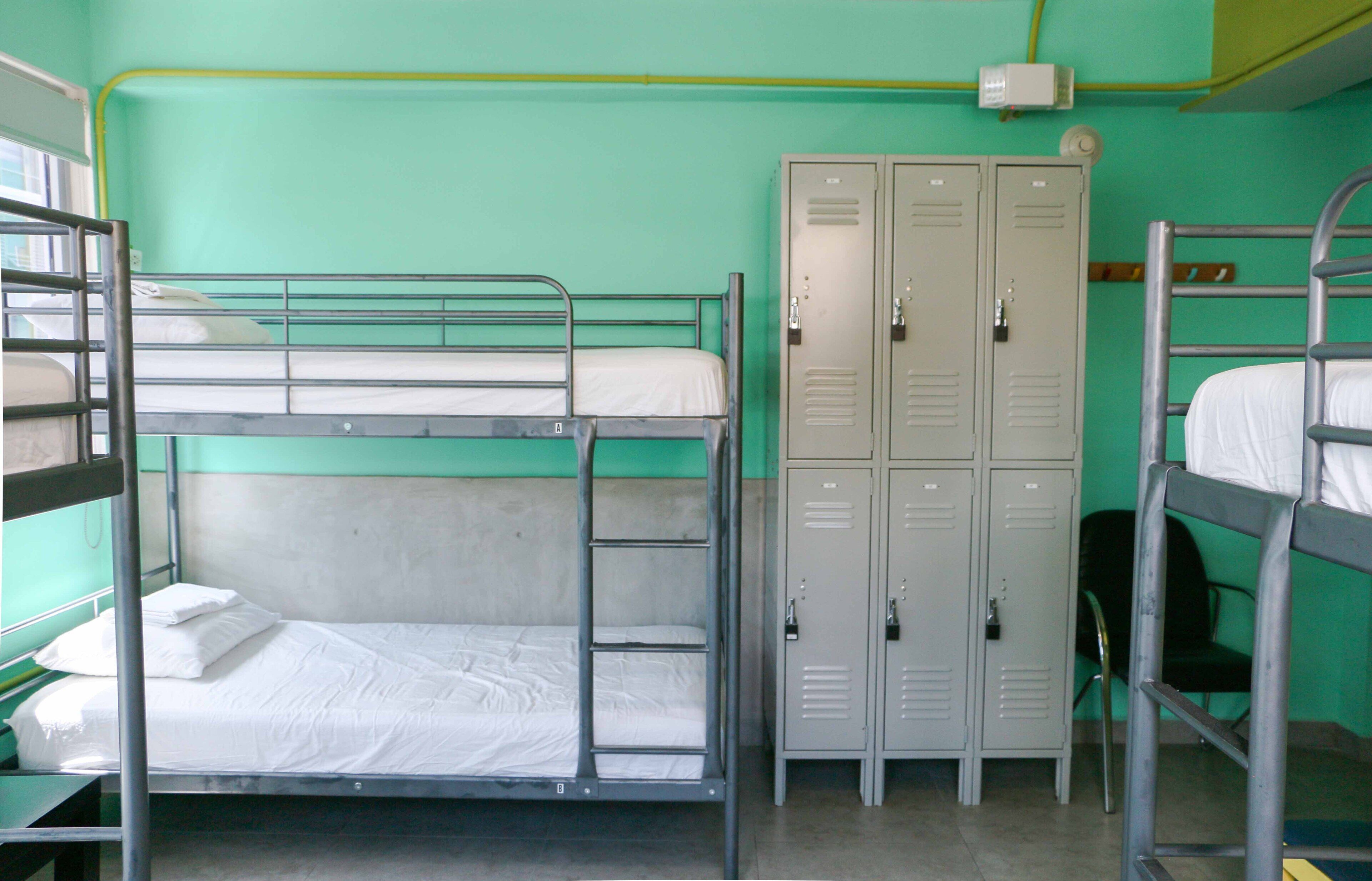 A bunk bed room with lockers and a chair.