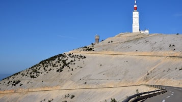 Eine kurvenreiche Straße an einem Hügel mit einem Leuchtturm und einem kleinen Turm in der Ferne.