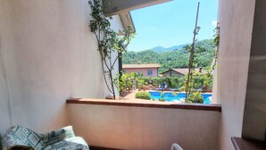 A balcony with a view of a swimming pool and greenery. - Villa Piazza, private solar heated pool,  walk to all facilities!  WIFI (Piazza al Serchio)