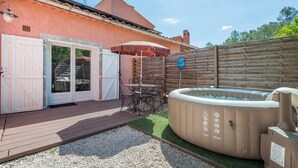 A patio with a hot tub, outdoor seating, and a wooden fence. - The Maison Rose studio (Callas)