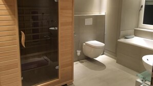 Ein modernes Badezimmer mit einer Duschkabine, einer Toilette und einem Waschbecken.