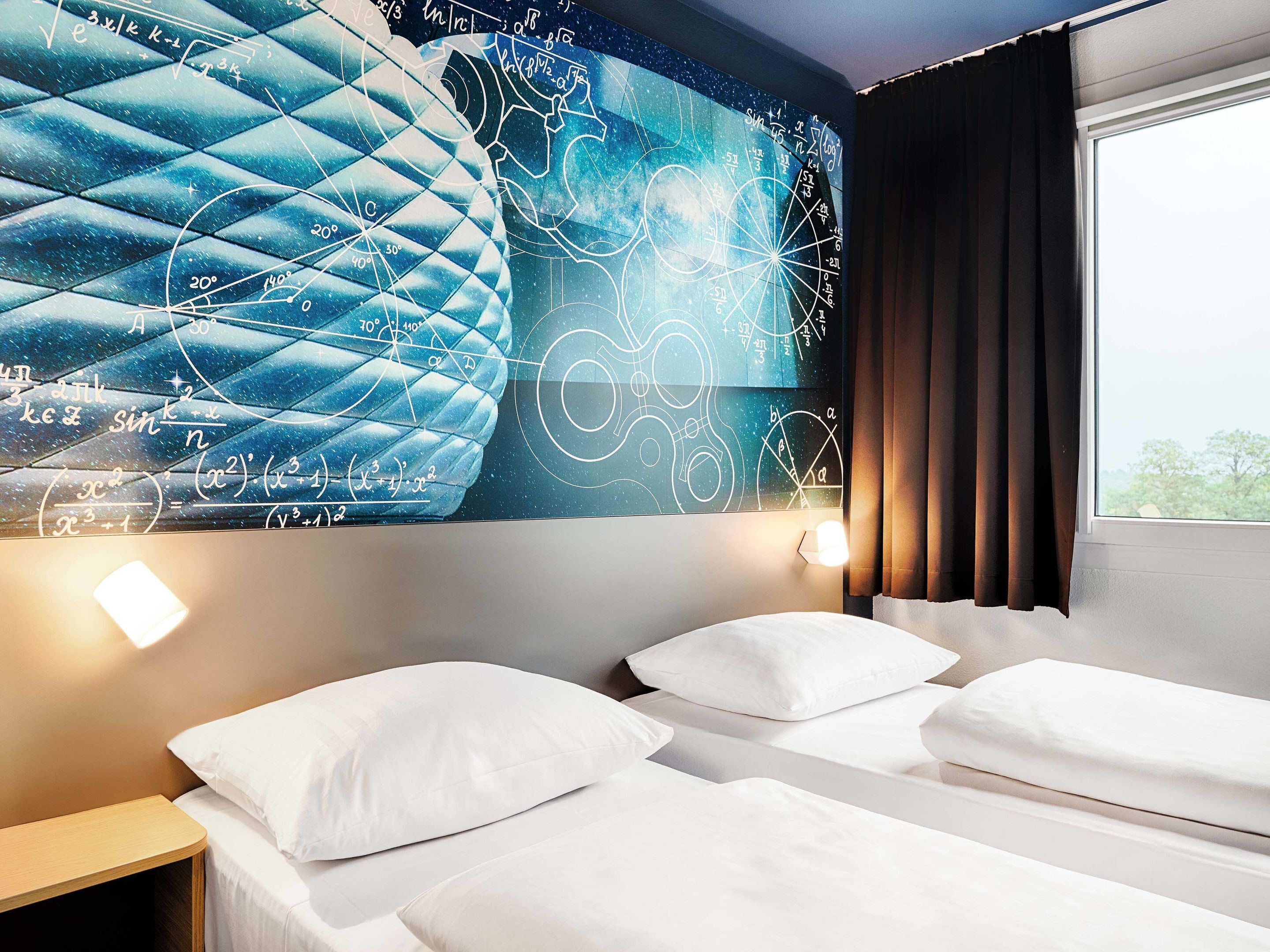 Une chambre d’hôtel avec un grand mur décoré d’une fresque représentant des équations mathématiques et une fenêtre avec des rideaux.