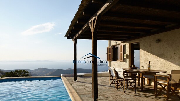 A poolside area with a table and chairs, a pergola, and a view of the mountains. - Pool garden house (Kea)