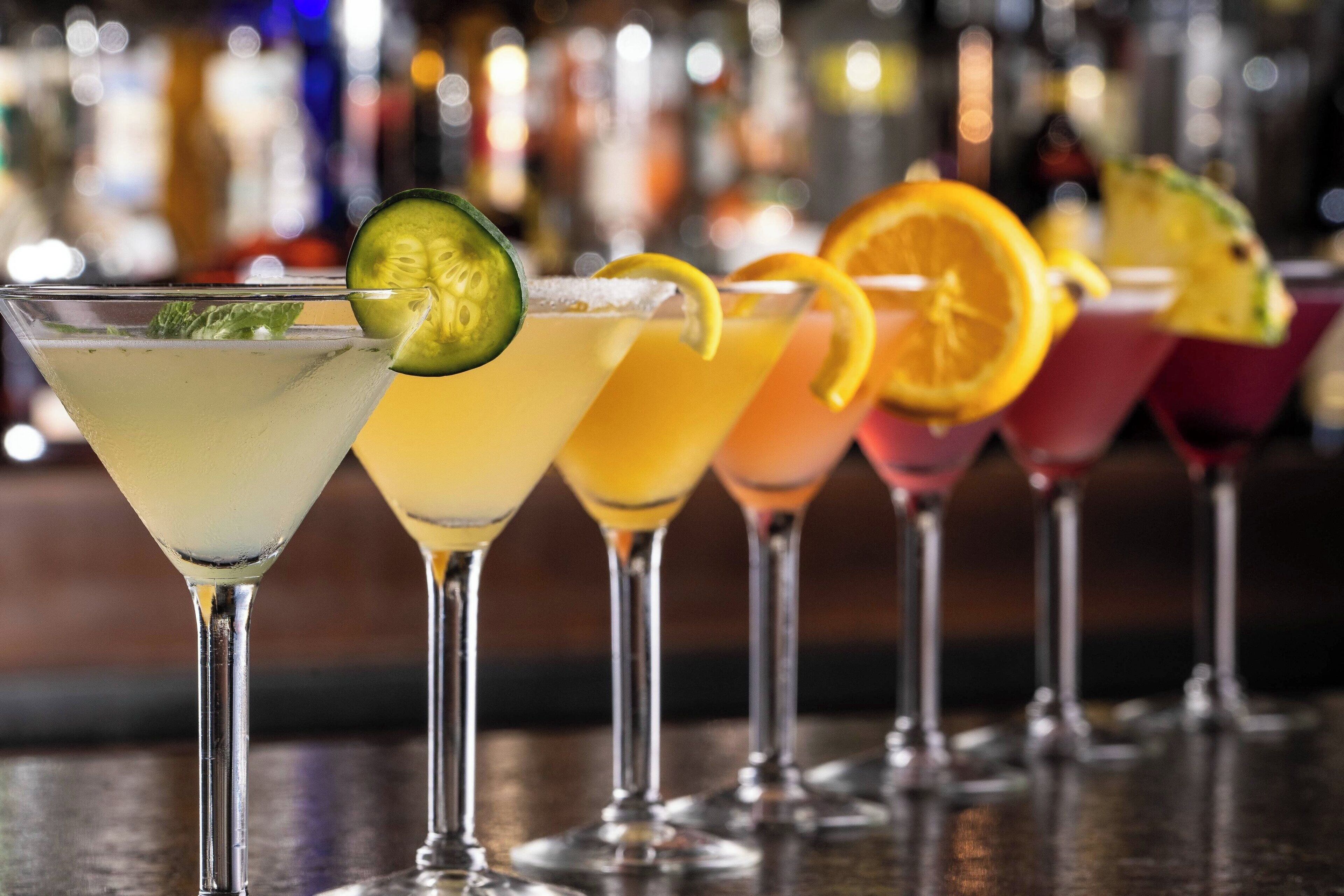 Una hilera de copas de martini con diferentes adornos.