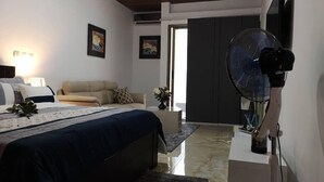 Un dormitorio moderno con cama, sofá, ventilador y obras de arte en las paredes.