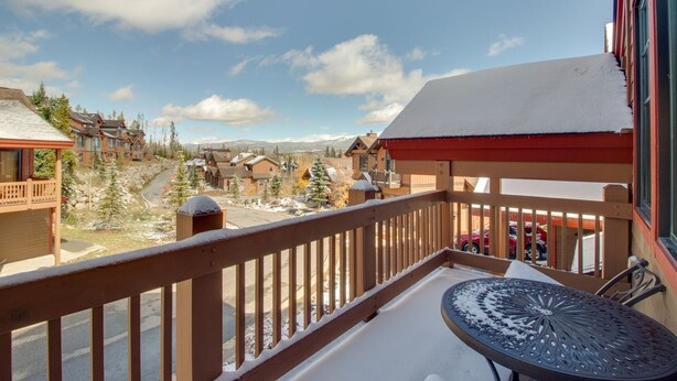 A balcony with a view of a snowy landscape and buildings.