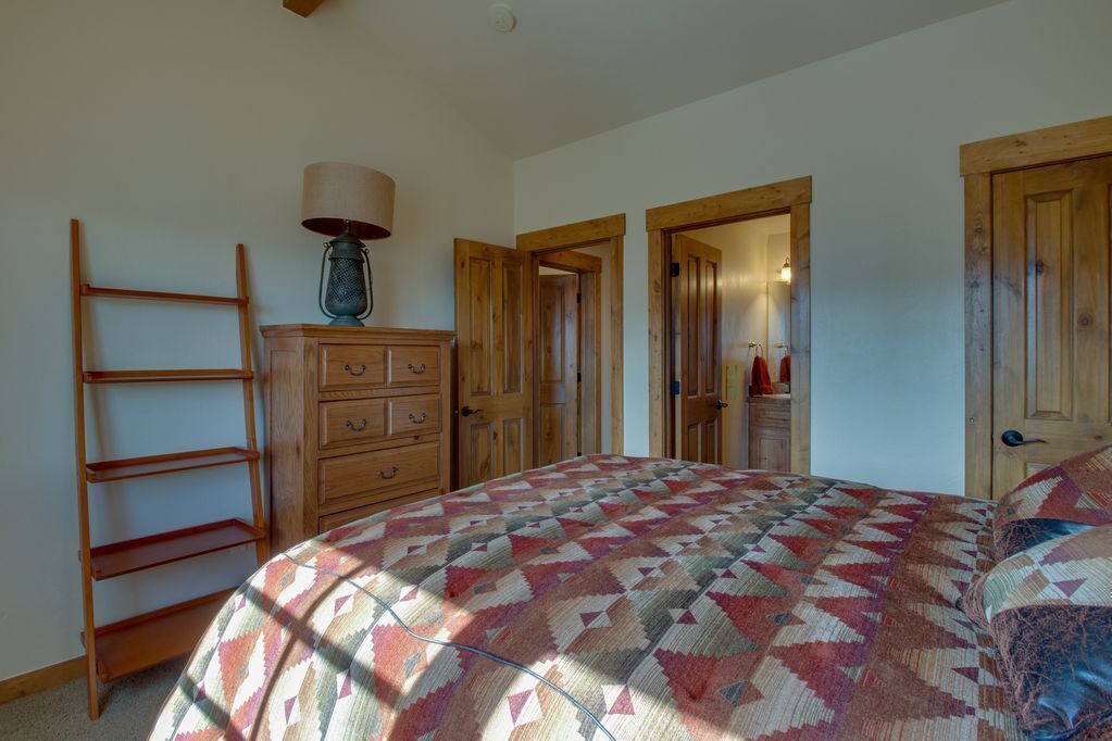 Une chambre à coucher avec un lit, une commode en bois et une échelle.