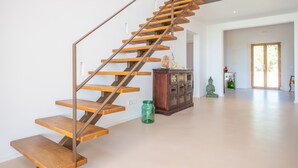 Een moderne trap met houten treden en metalen leuningen, die naar de tweede verdieping leidt.