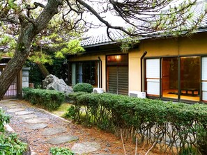Un edificio in stile tradizionale giapponese con un vialetto in pietra che conduce all'ingresso.