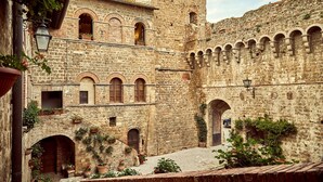 Un edificio histórico de piedra con múltiples arcos y una torre.