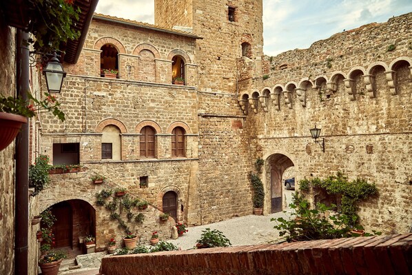 Un edificio histórico de piedra con múltiples arcos y una torre.