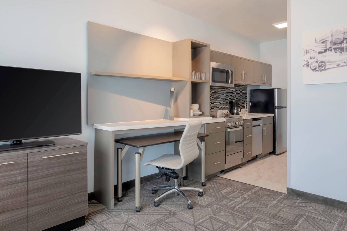 Una cocina moderna con televisor de pantalla plana, una mesa de comedor y una isla de cocina.