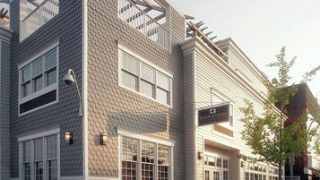 Een gebouw met twee verdiepingen, uitgevoerd in een modern architectonisch ontwerp, met een patroonvormig gevelwerk en meerdere ramen.