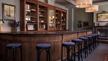 A bar area with wooden bar stools and a bookshelf.