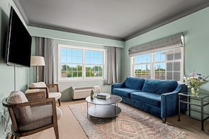 Relax in this stylish living room with a comfortable sofa, flat-screen TV, and wicker chair.
