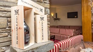 Une bouteille de vin en bois, dans une boîte portant l’inscription « Borgo Molino », posée sur une étagère en pierre.