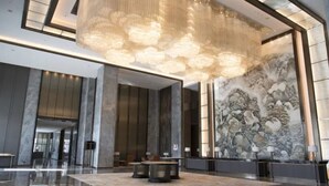 A spacious lobby with a large chandelier, a traditional mural, and a reception desk. - Wanda Vista Changchun (Changchun)