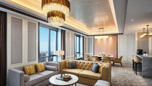 A spacious living area with a large sofa set, a coffee table, and a dining area with chairs and a table. - Wanda Vista Changchun (Changchun)