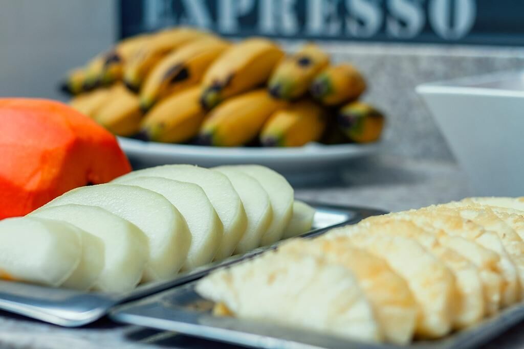 Un plato con rodajas de manzana, un bol de plátanos y un bol que parece un postre o una pastelería.