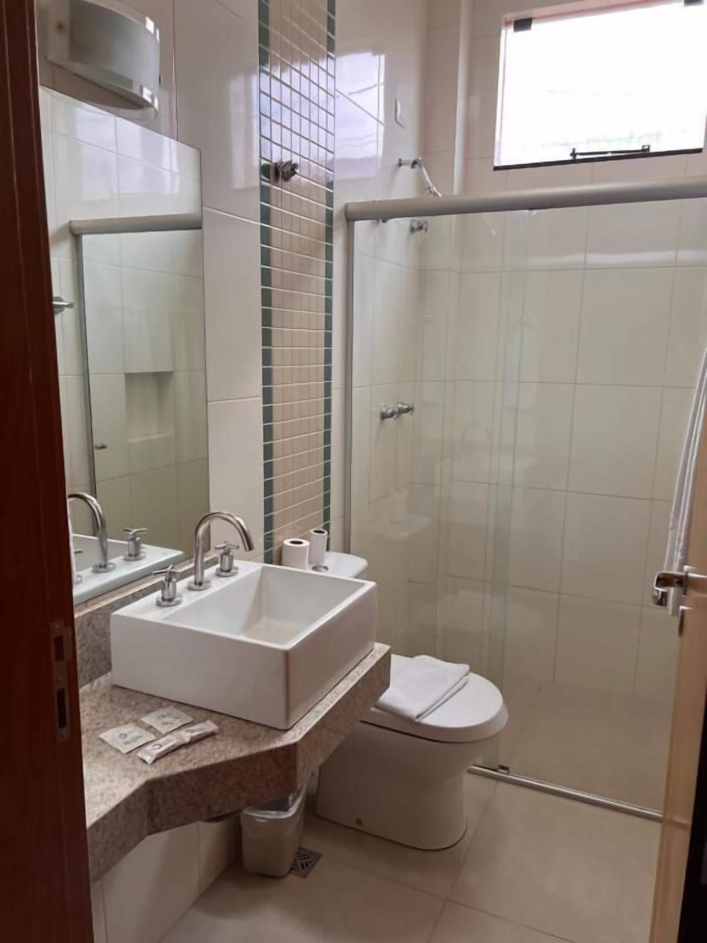 Ein Badezimmer mit Waschbecken, Toilette und Dusche.