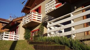 A two-story building with balconies, a sloped roof, and a clear sky.